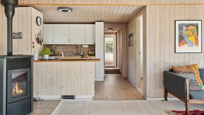 Una cocina moderna con armarios de madera, una isla central y un estufa de leña.