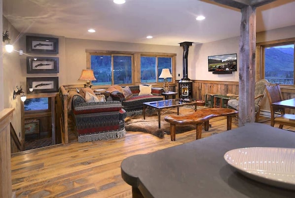 A cozy living room with a sofa, a table, and a fireplace.