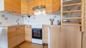 A kitchen with wooden cabinets, a white stove, and a tiled backsplash.