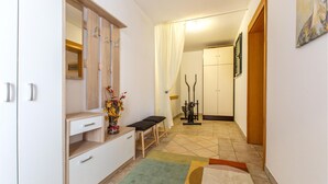 A hallway with a bench, a small table with a vase, and a treadmill.