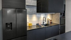 Une cuisine moderne équipée d’un réfrigérateur encastré, d’un évier et d’une cuisinière.