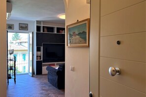 A living room with a sofa, TV, and shelves.