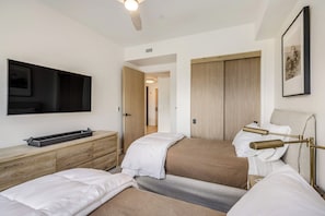 A hotel room with a bed, bedside tables, a TV, and a wardrobe.