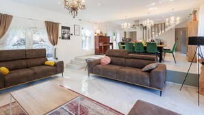 Un grand salon comprenant deux canapés, une table basse et un coin repas avec une table et des chaises.