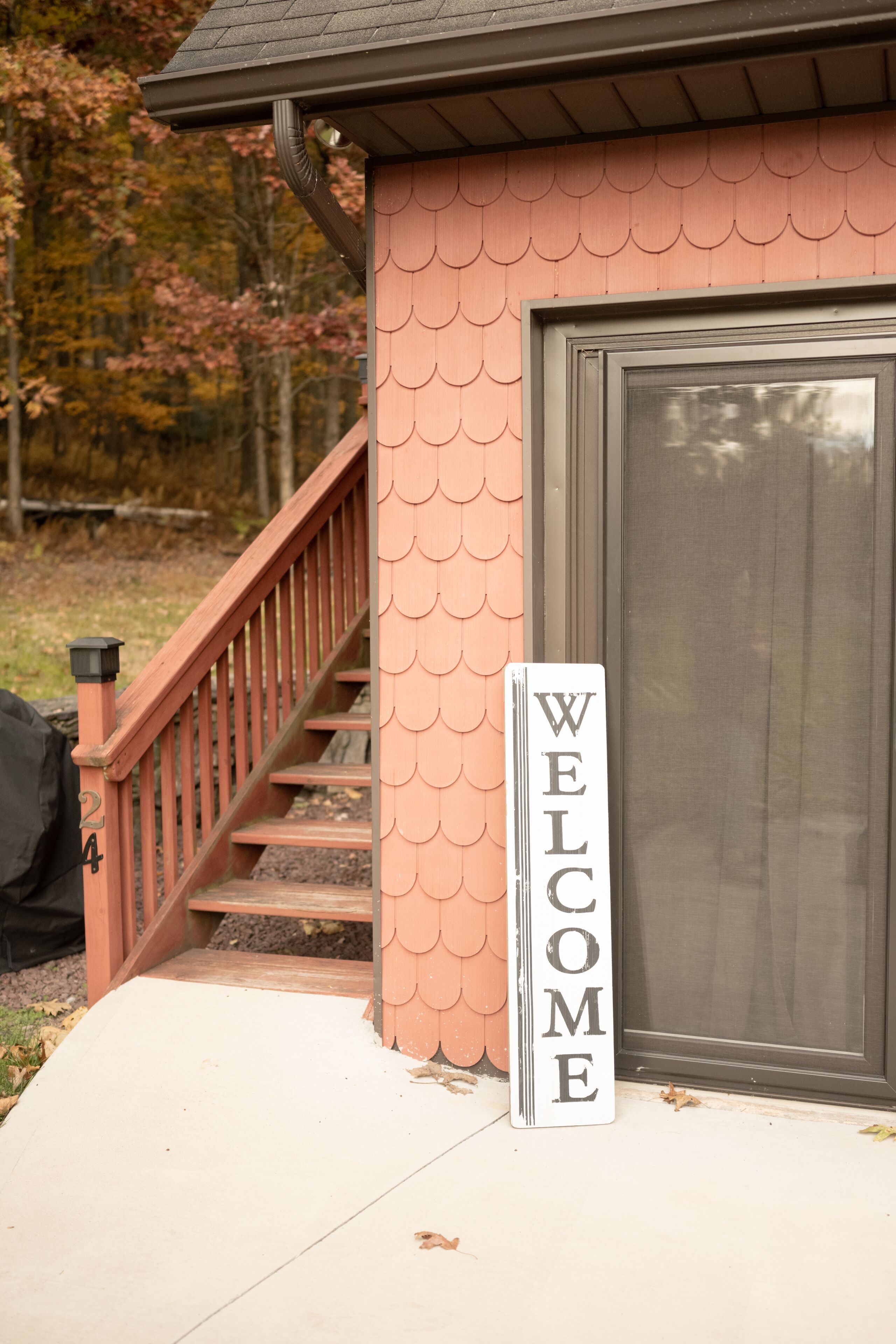 A house with a 'WELCOME' sign, a staircase, and a door.