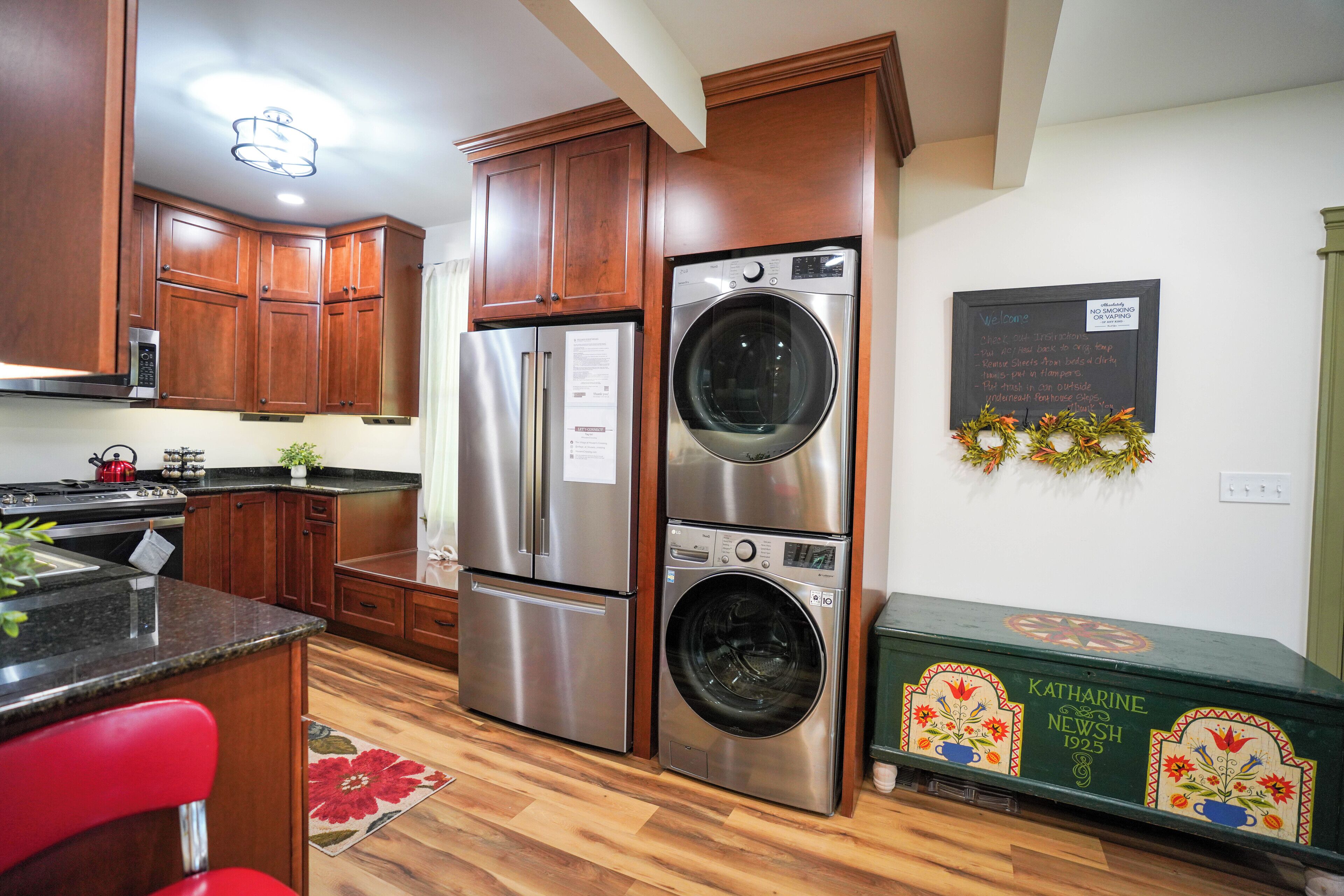 Una cocina con gabinetes de madera, electrodomésticos de acero inoxidable y un aparador verde.