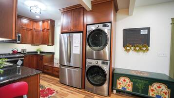 Una cocina con gabinetes de madera, electrodomésticos de acero inoxidable y un aparador verde.