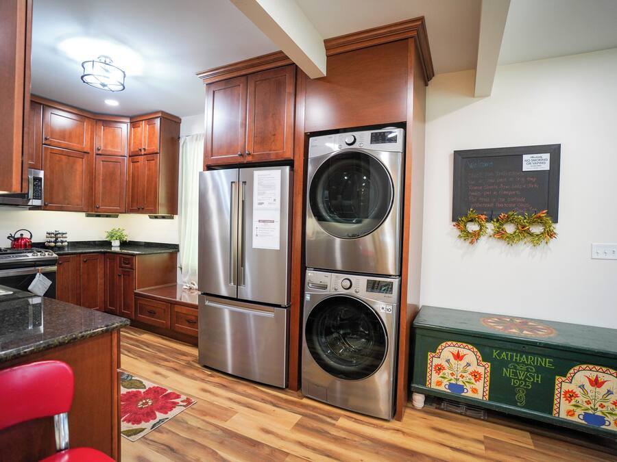 Una cocina con gabinetes de madera, electrodomésticos de acero inoxidable y un aparador verde.