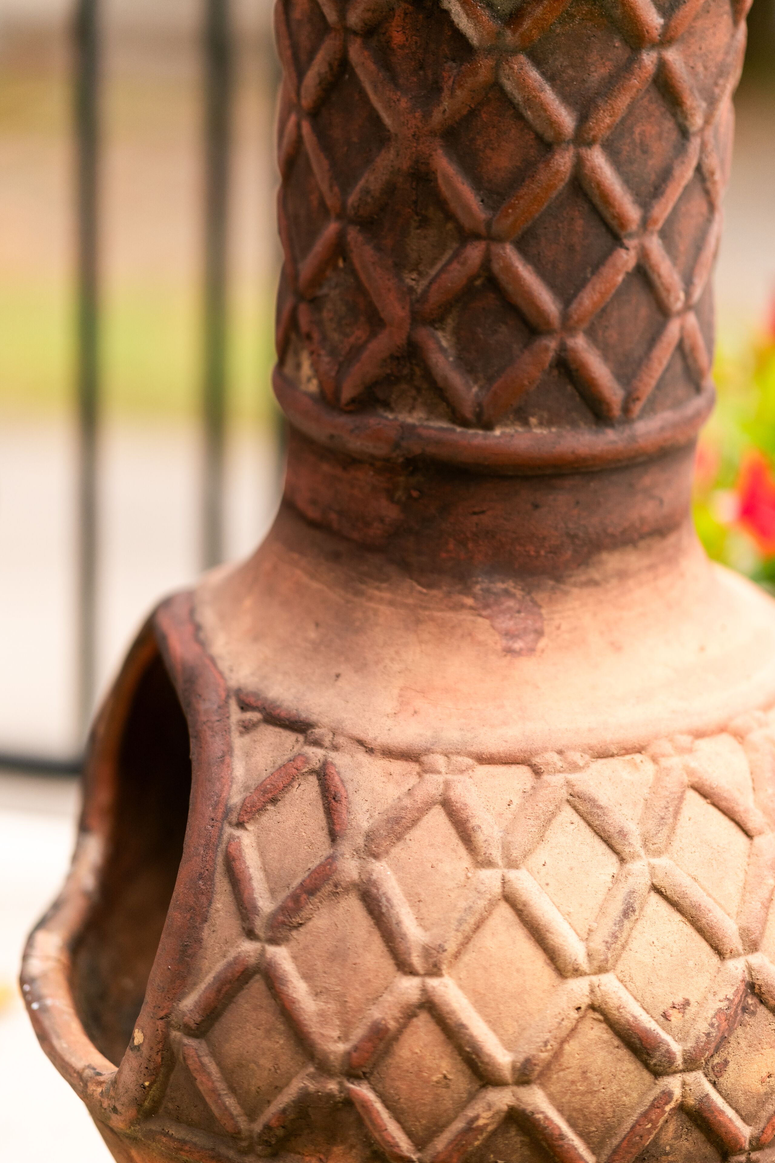 A close-up of a terracotta pot with a textured pattern.