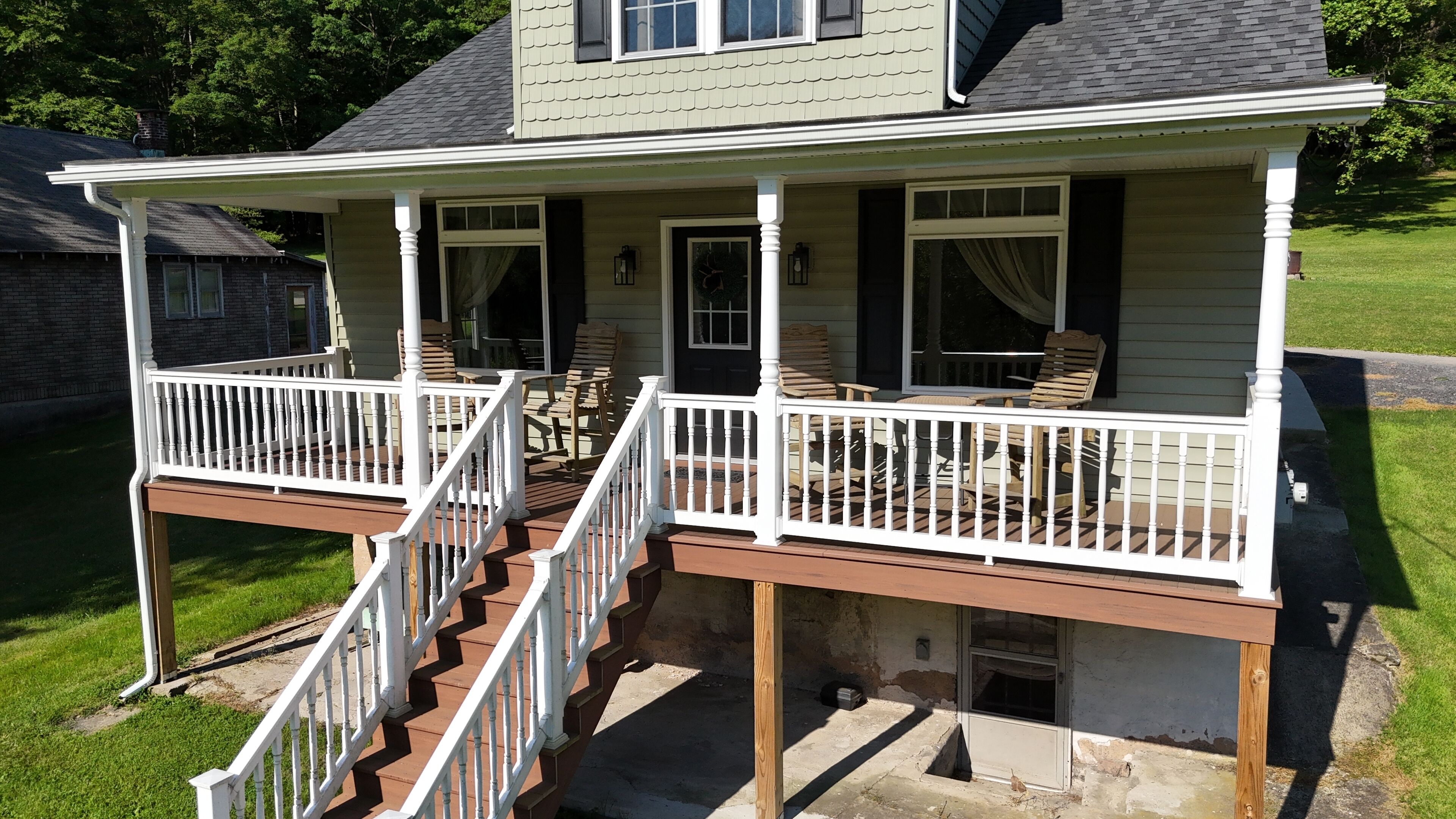 A two-story house with a covered porch and a staircase.