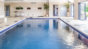 Ein Indoor-Pool mit klarem Wasser, Fliesenboden und modernem Design.