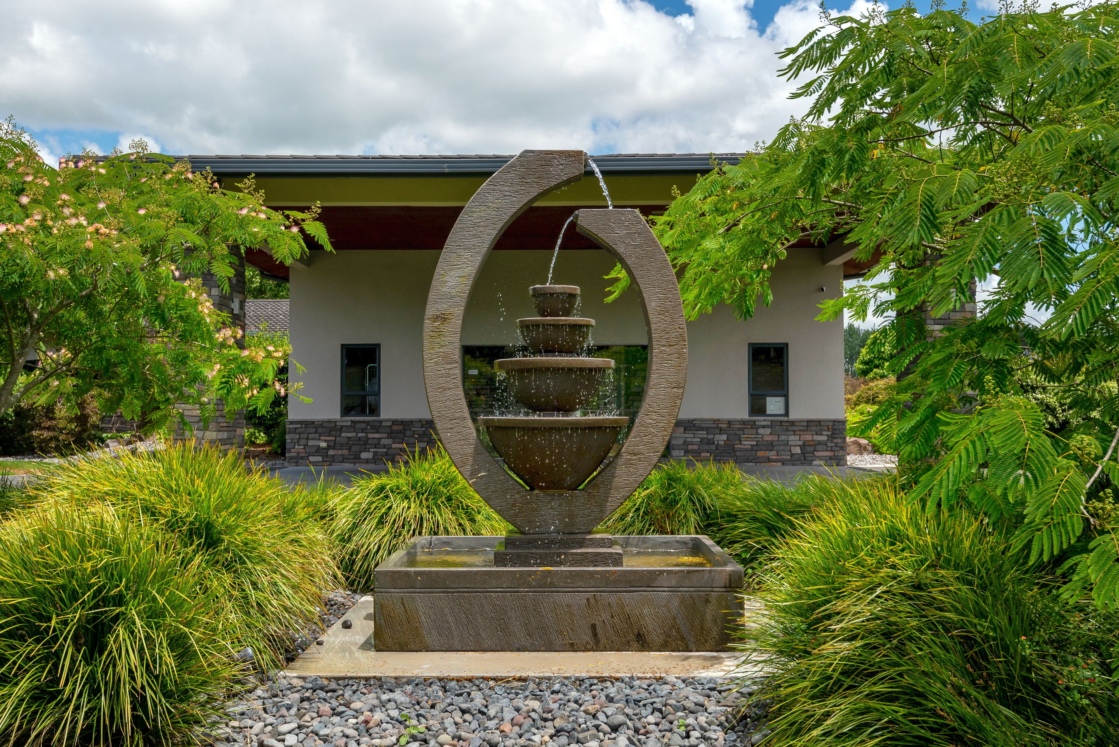 Ein Brunnen mit kreisförmigem Design vor einem Gebäude.