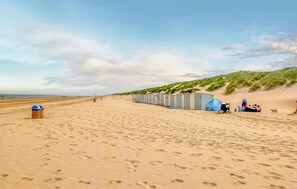 Ein Strand mit mobilen Toiletten und einem für das Campen aufgebauten Zelt.