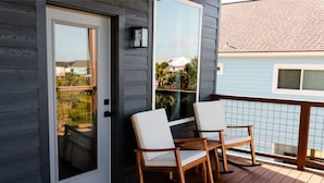 En träveranda med två gungstolar och en skjutdörr av glas.