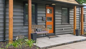 Une maison avec un porche, un banc et une porte portant le numéro 2838.