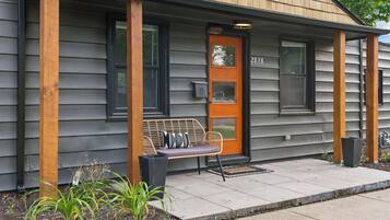 Une maison avec un porche, un banc et une porte portant le numéro 2838.