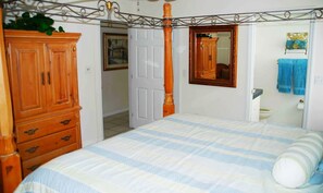 Classic bedroom with a four-poster bed, wooden wardrobe, and decorative metal ceiling.