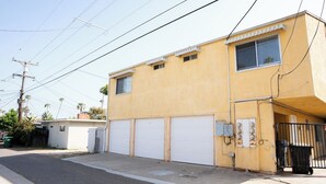 Un edificio a due piani con un garage e una piccola costruzione adiacente.