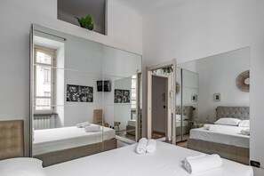 Ein Schlafzimmer mit zwei Betten, einem großen Spiegel und Bildern an den Wänden.