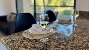 A dining table with a glass of white wine, a plate, and a napkin. - Hotel Rioverde- 5 minutos de cercanía al aeropuerto (Rionegro)