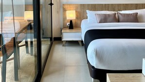 A modern hotel room with a large bed, bedside table, and a glass partition wall. - Hotel Rioverde- 5 minutos de cercanía al aeropuerto (Rionegro)