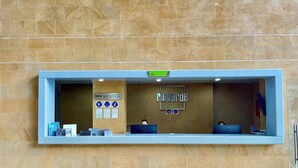A reception desk with a sign reading "Pioverde" and "Reception." There are informational posters and a computer on the desk. - Hotel Rioverde- 5 minutos de cercanía al aeropuerto (Rionegro)