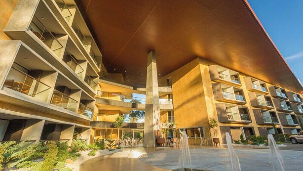 A modern building with multiple balconies, a central fountain, and a covered walkway. - Hotel Rioverde- 5 minutos de cercanía al aeropuerto (Rionegro)