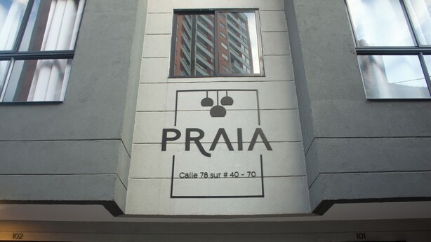 A building with a sign reading "PRAIA" and "Calle 78 sur #40-70". - Praia Apartaestudios (Sabaneta)