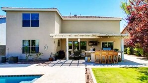 A two-story house with a patio area, a pool, and a garden. - Stunning Heated Pool +Game Room +Great Location
 (Gilbert)