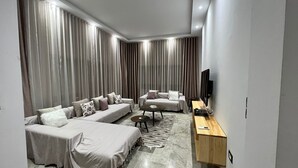 Un salon moderne comprenant un canapé, une table basse et un téléviseur.