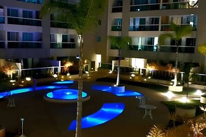 A courtyard with a central water feature, surrounded by buildings with balconies and windows.