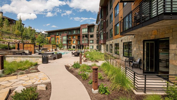 A modern building with a pool, outdoor seating, and a stone pathway. - Unbeatable Location! Near Hiking Trails! Park City Lift 301 Ski-in/Ski-out (Park City)