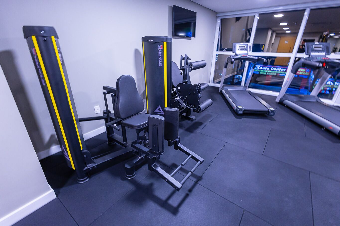 Un gimnasio con equipo de ejercicio, que incluye máquinas de pesas y cintas de correr.