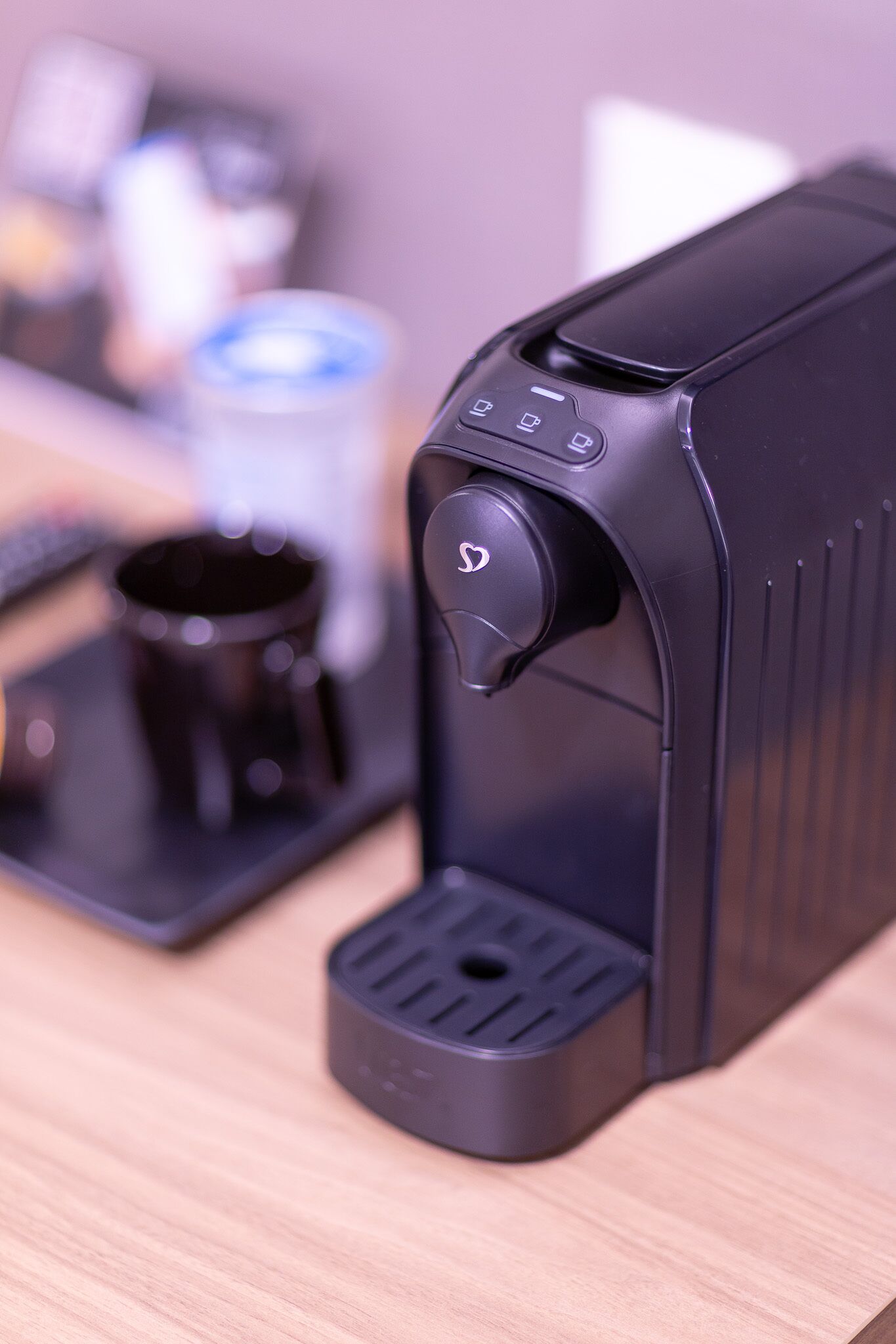 Una cafetera con panel de control y portavasos.