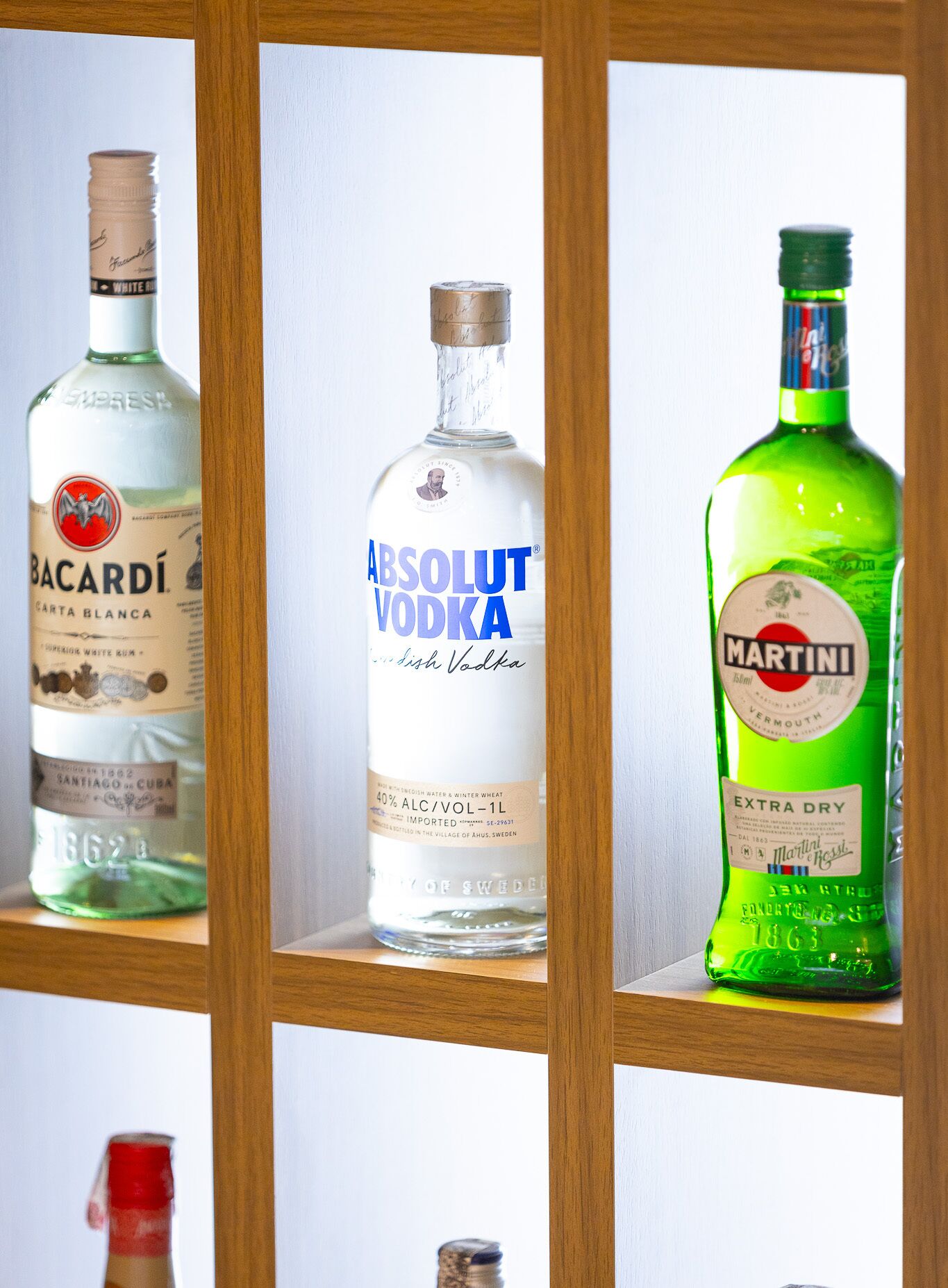 Tre bottiglie di vodka su uno scaffale.