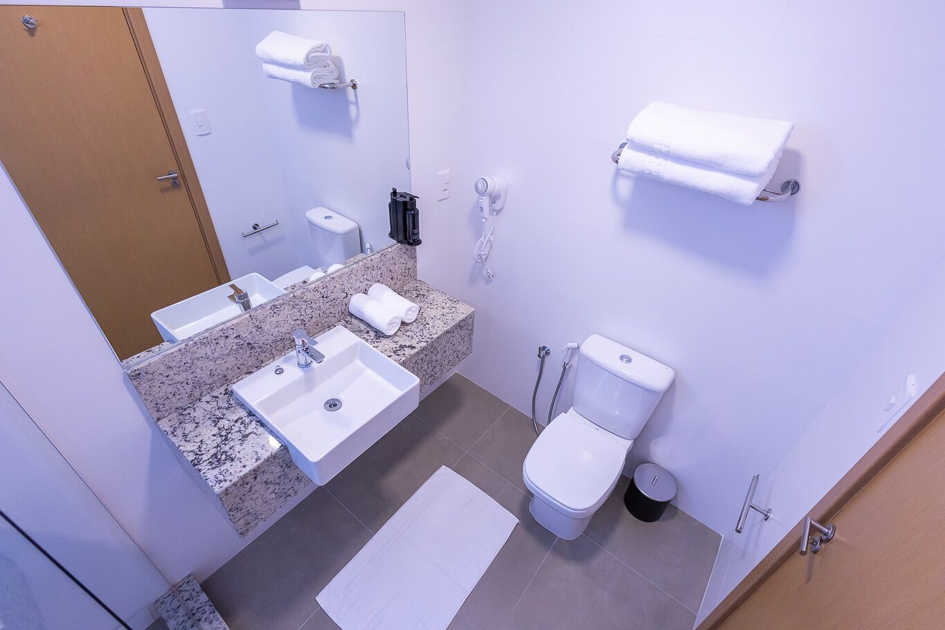 Un baño moderno con dos lavamanos, un inodoro y un espejo.