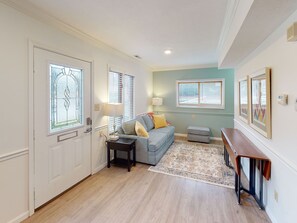 A living room with a sofa, a small table, a rug, and a bench.