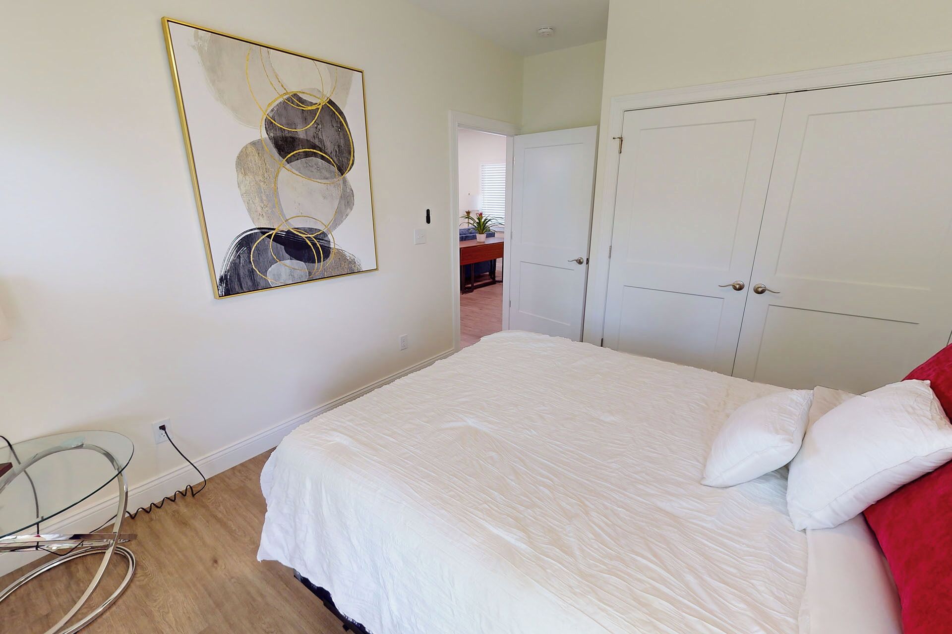 Un dormitorio con cama, armario y un cuadro en la pared.