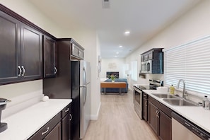 A modern kitchen with dark cabinetry, stainless steel appliances, and a central island.
