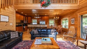 A cozy cabin interior with a living room, kitchen, and dining area. - Morris Cabin- Cedar log cabin with hot tub, dog friendly, mountain views (Boone)