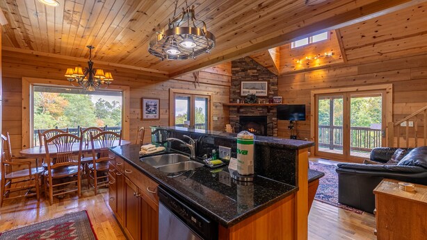A wooden cabin interior with a kitchen, dining area, and living room. - Morris Cabin- Cedar log cabin with hot tub, dog friendly, mountain views (Boone)