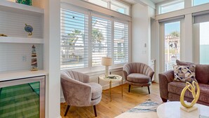 Un salon spacieux doté d’une grande fenêtre, d’une cheminée et d’un coin salon confortable avec un canapé et des fauteuils.