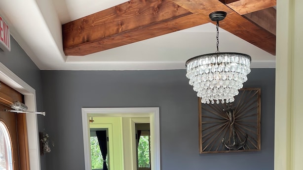 Un couloir doté d’un plancher en bois, d’un lustre et d’une décoration murale en forme d’ancre.