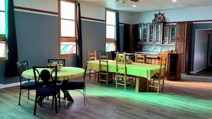 Un coin repas avec une table ronde, des chaises et un ventilateur de plafond.