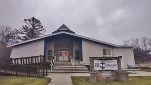 Une église à la façade blanche, à l’entrée bleue, et sur laquelle on peut lire l’inscription « Hubbard Lake Community ».