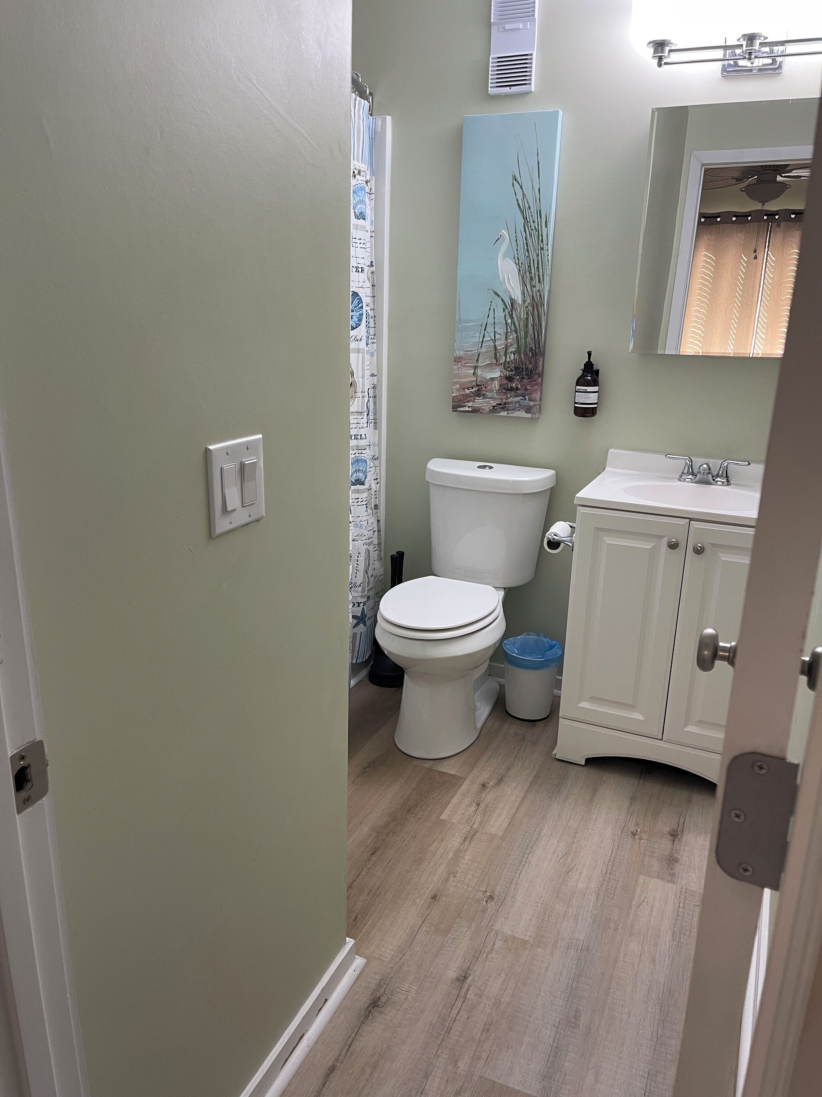 Une salle de bain avec des toilettes, un lavabo et un meuble de rangement.