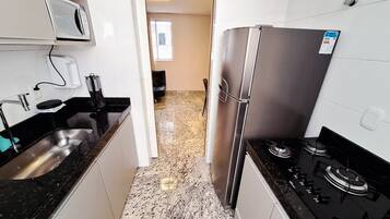 Appartement | Privékeuken | Een koelkast met diepvriezer, een microgolfoven, een kookplaat