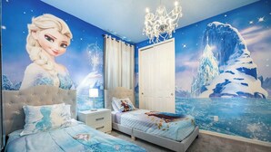 Een slaapkamer met een groot muurschildering van een winters landschap, een kroonluchter en een bed met een passend ontwerp.
