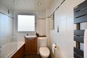 A modern bathroom with a bathtub, a sink, and a toilet.