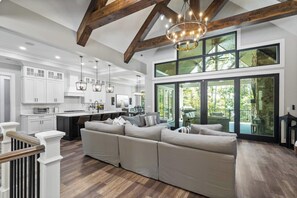 A modern kitchen with white cabinets, a large island, and pendant lighting.